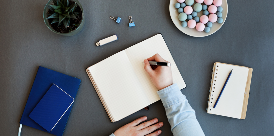 hand schrijft in notitieboek|man plakt post-it notes op een muur