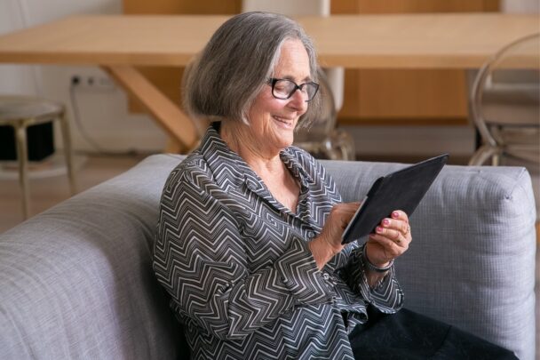 Vrouw maakt op de bank gebruik van een tablet.