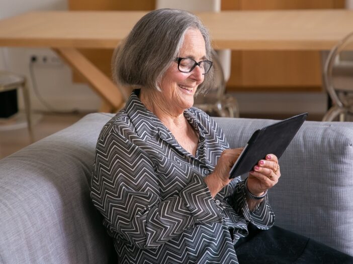 Vrouw maakt op de bank gebruik van een tablet.