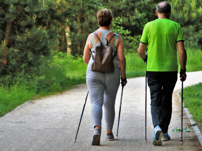 Man en vrouw wandelen samen met nordic walking stokken