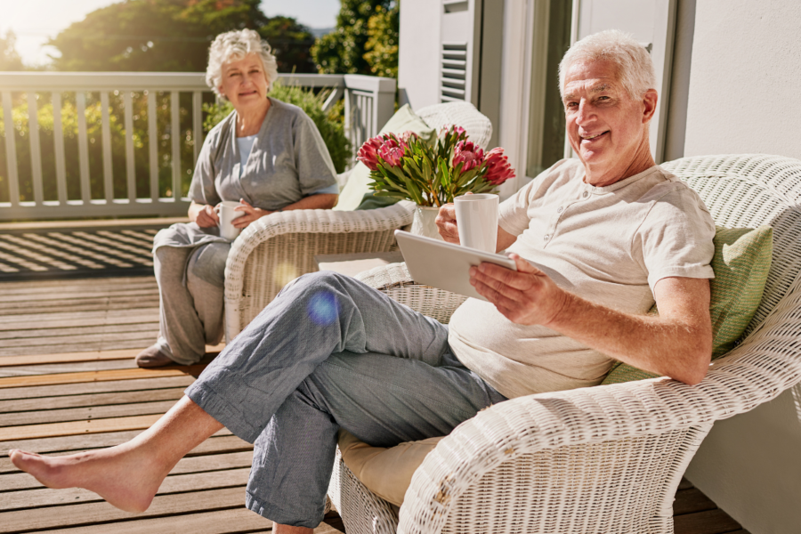 oudere man en vrouw zitten samen in de zon te genieten