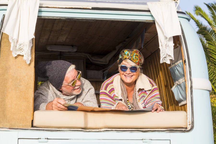 Oudere man en vrouw liggen in hun camper van de zon te genieten