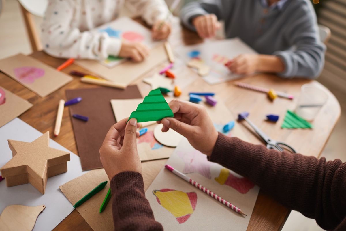 kinderen knutselen aan een tafel vol knutselspullen