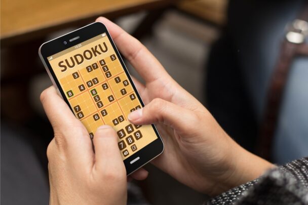 Iemand speelt sudoku puzzel op zijn mobiel