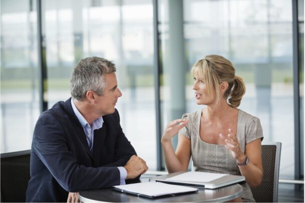 Man en vrouw voeren een serieus gesprek in een kantoorsetting