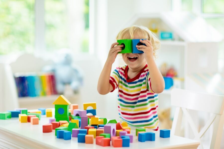 Kind is met gekleurde blokjes aan het spelen op de kinderopvang.