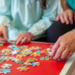 Oudere dame legt een legpuzzel samen met een jongere vrouw