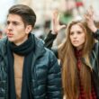 Jonge man en vrouw hebben een discussie op straat. De vrouw houdt geërgerd haar handen in de lucht.