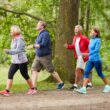 Vier mensen wandelen in een bosrijke omgeving