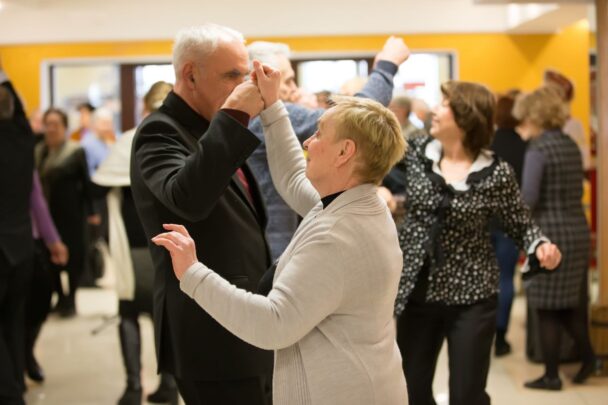 Groepje ouderen is gezellig samen aan het dansen.