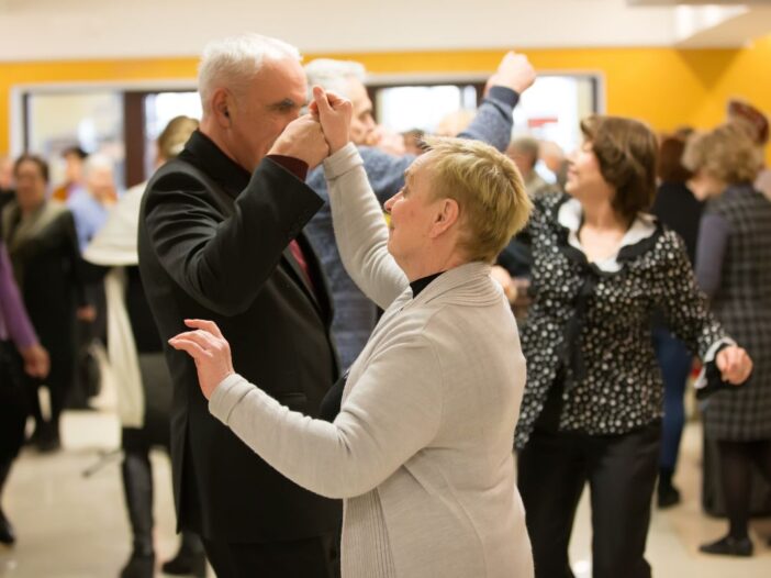 Groepje ouderen is gezellig samen aan het dansen.