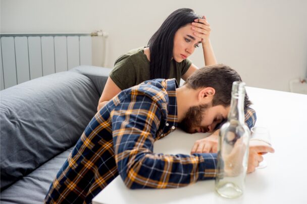 Man en vrouw hebben ruzie en verdriet over het drankprobleem van de man.