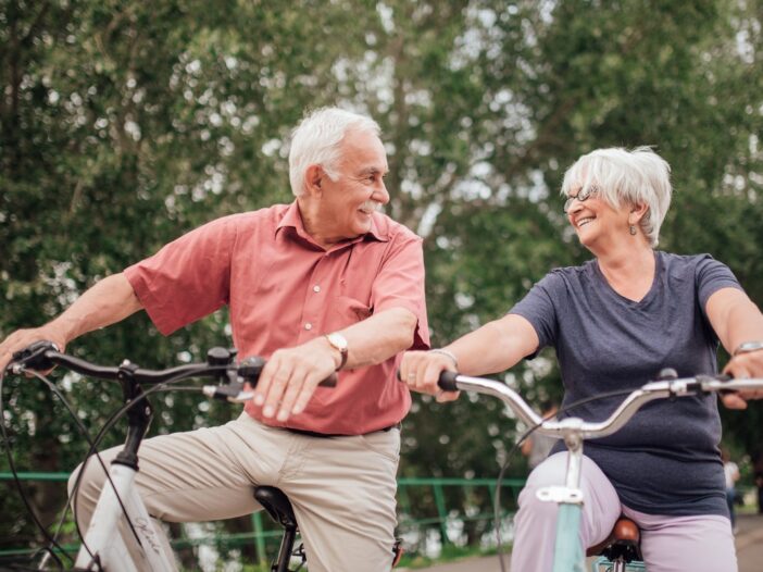 Twee ouderen zijn samen aan het fietsen.