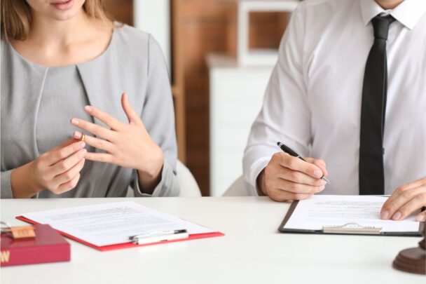 Man en vrouw gaan scheiden en zitten aan tafel om papieren te ondertekenen.