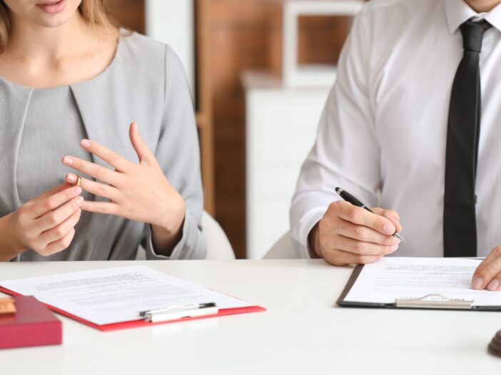 Man en vrouw gaan scheiden en zitten aan tafel om papieren te ondertekenen.