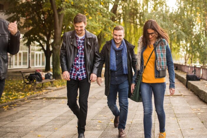 Twee mannen en een vrouw maken een wandeling buiten.